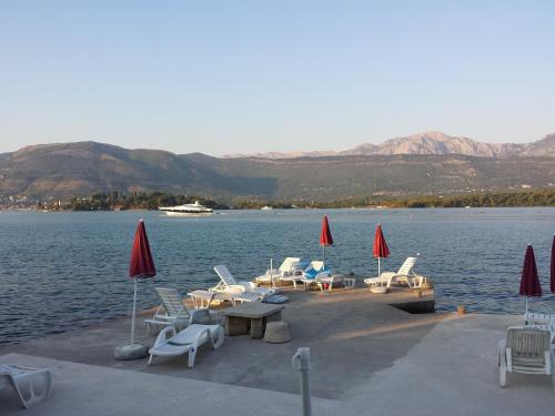 a group of chairs and tables on a dock in the water at Apartments Klakor PS in Tivat