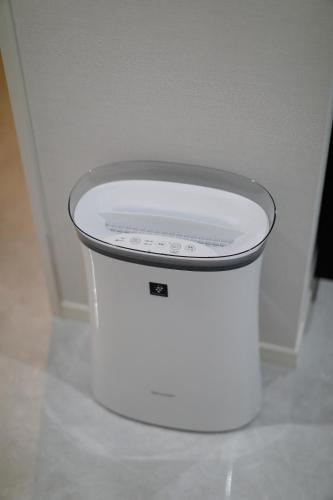 a white trash can in the corner of a room at コンドミニアムHARU 那覇県庁前 201 in Naha