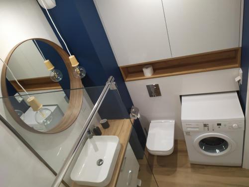 y baño con espejo y lavadora. en Kraków Navyblue Luxury & Home Office Friendly Apartment by M&P, en Cracovia