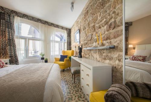 a bedroom with a bed and a desk and a chair at Casa del ancla in Muros