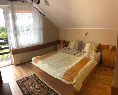 a bedroom with a large bed and a window at Pensjonat Klaudia in Ostrowo