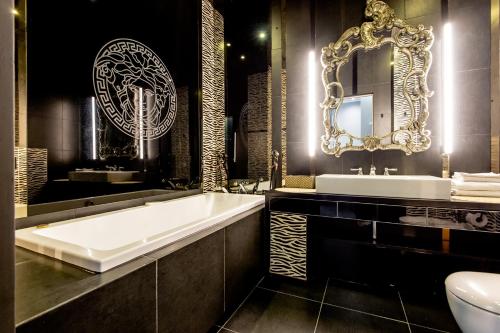 a bathroom with a tub and a sink and a mirror at Super-Apartamenty City Park I BASEN, SAUNA in Poznań