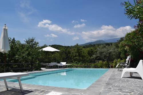 una piscina con mesa y sillas junto a ella en Le Case Di Bacco, en Santa Venerina