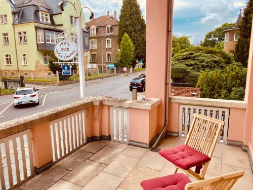 a balcony with two chairs and a view of a street at Villa Antonia in Bautzen