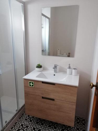 a bathroom with a sink and a mirror at Póvoa City Center Apartment in Póvoa de Varzim