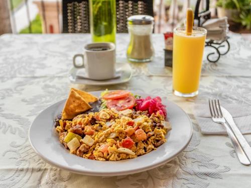 a plate of food on a table with orange juice at Hotel Tepeyac in San Cristóbal de Las Casas