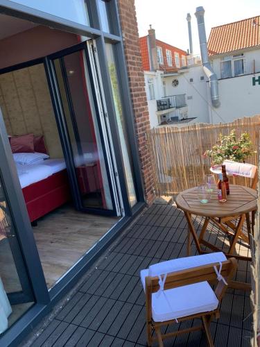 a balcony with a table and chairs and a bed at The Rock in Zandvoort