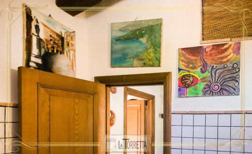 a room with paintings on the wall and a door at B&B La Torretta in Maratea