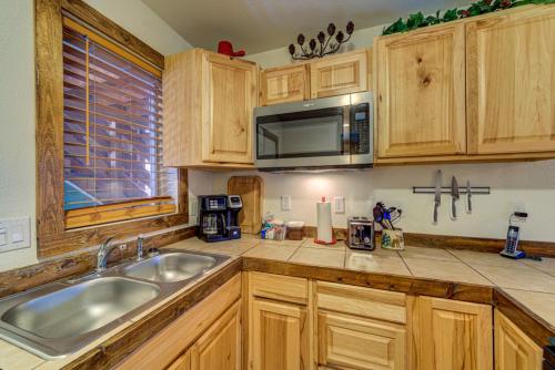 a kitchen with wooden cabinets and a sink and a microwave at Green Mountain Falls Lodge in Green Mountain Falls