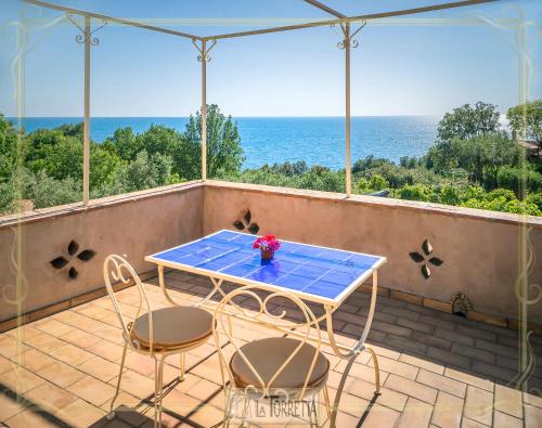 a table and chairs on a balcony with a view of the ocean at B&B La Torretta in Maratea