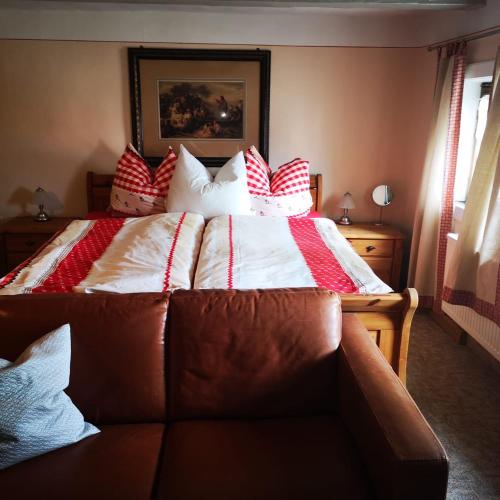 a bedroom with a large bed with red and white pillows at Ferienhof Plotzen in Hochkirch