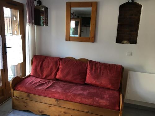 a red couch sitting in the corner of a room at Chez polyte in Bourg-Saint-Maurice