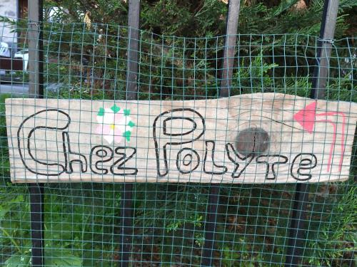 a sign on a fence that says play dog poopride at Chez polyte in Bourg-Saint-Maurice