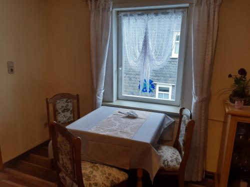 a table and chairs in front of a window at Haus Bösenberg in Altenau