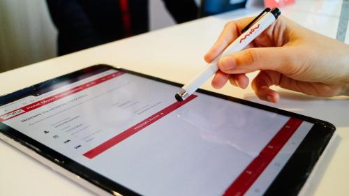 a person holding a pen and a tablet at Moov Hotel Porto Norte in Porto
