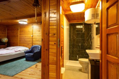 ein Bad mit einem Bett, einer Dusche und einem Waschbecken in der Unterkunft AB Domki całoroczne nad jeziorem in Stęszew