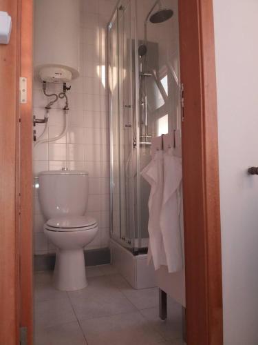 a bathroom with a toilet and a glass shower at Casa do Rio - Riverside House in Seixal