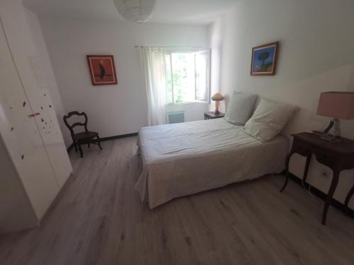 une chambre avec un lit, une table et une fenêtre dans l'établissement Séjour au calme au milieu des vignes, à Loupian