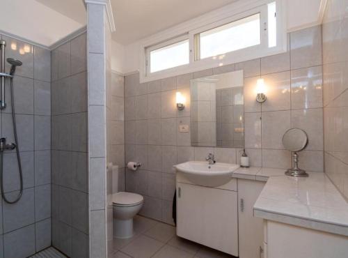 a bathroom with a toilet and a sink and a shower at Villa Sue in Palm-mar