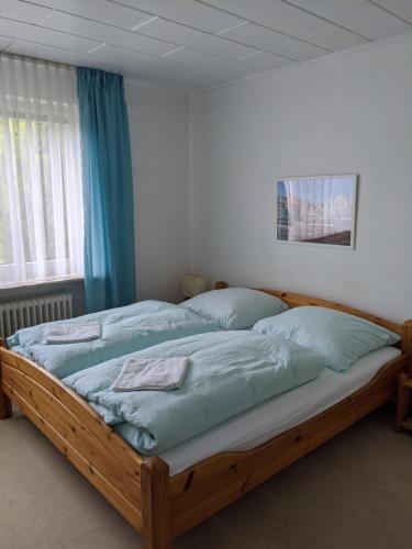 a bedroom with a large wooden bed with blue sheets at Privatzimmer Sutanto in Reppenstedt