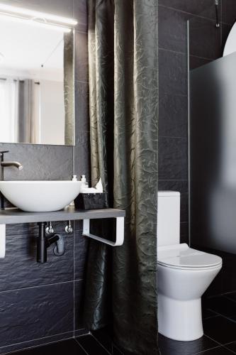a bathroom with a sink and a toilet and a mirror at Downtown Loulé in Loulé