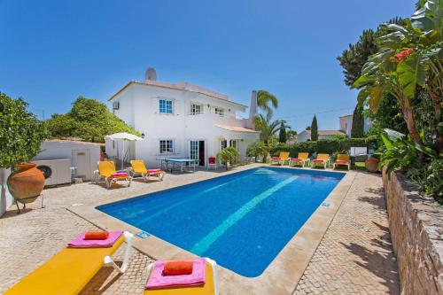 a villa with a swimming pool in front of a house at Vivenda Gabriel #vivgabriel in Albufeira
