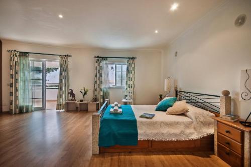 a bedroom with a large bed with a blue blanket at Vivenda Gabriel #vivgabriel in Albufeira