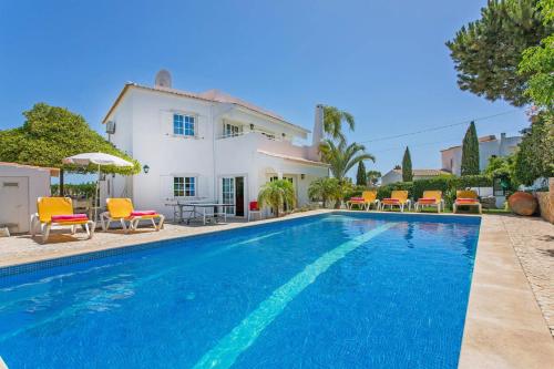 a villa with a swimming pool in front of a house at Vivenda Gabriel #vivgabriel in Albufeira