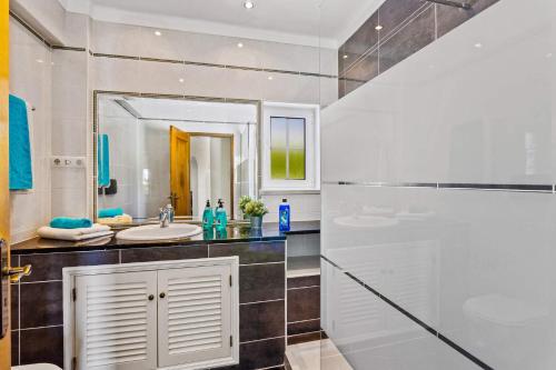 a bathroom with a sink and a mirror at Vivenda Gabriel #vivgabriel in Albufeira