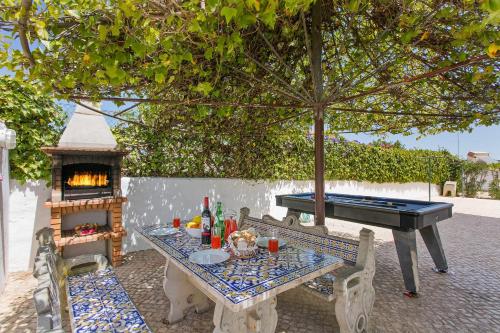 a ping pong table with a grill and a table with a ping pong at Vivenda Gabriel #vivgabriel in Albufeira