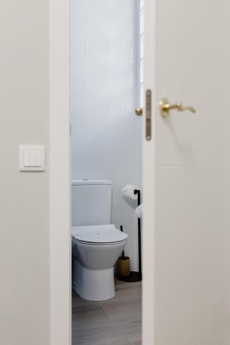 a bathroom with a white toilet in a room at Downtown Loulé in Loulé
