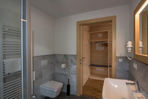 a bathroom with a toilet and a sink at Eco-Green Fiores Agriturismo in Vigo di Fassa