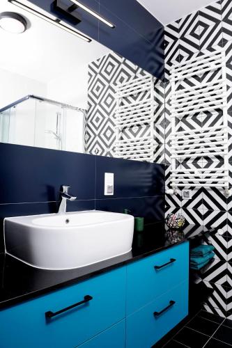 a bathroom with a sink and a blue wall at Sleep Well Inżynierska in Wrocław