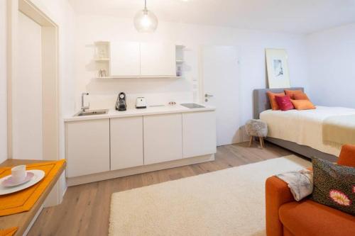 een slaapkamer met een bed en een keuken met een wastafel bij Apartment Vroni in Salzburg