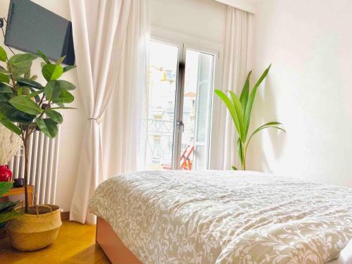 a bedroom with a bed and a large window at Downtown Boutique Apartment in Thessaloniki