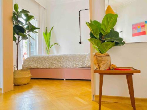 a room with a bed and a table with plants at Downtown Boutique Apartment in Thessaloniki