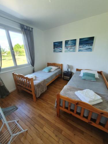 a bedroom with two beds and a large window at Santa Maria in Saint-Ouen-de-Mimbré