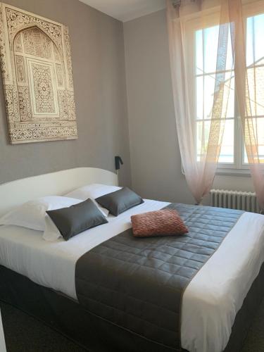 a large bed in a bedroom with a window at L'Escale de la Gare in Saumur