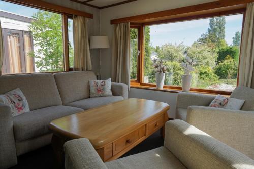 a living room with couches and a wooden coffee table at Chalet at a holiday park in Opmeer near Amsterdam in Opmeer