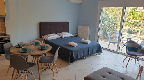 1 dormitorio con 1 cama, mesa y sillas en Eretria Apartments FM14, en Eretria