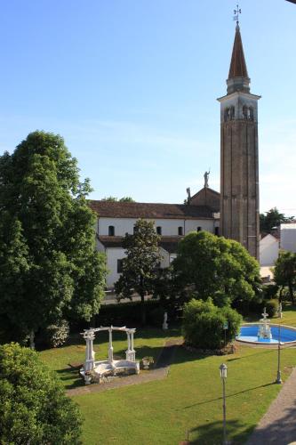 a large building with a clock tower in a park at Hotel Villa Stucky in Mogliano Veneto