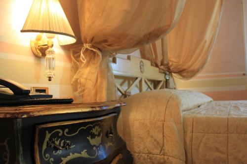 a bedroom with a bed and a table with a lamp at Hotel Villa Stucky in Mogliano Veneto