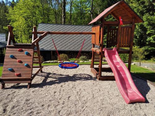 a playground with a slide and a play structure at Chata Harmonie in Bedřichov