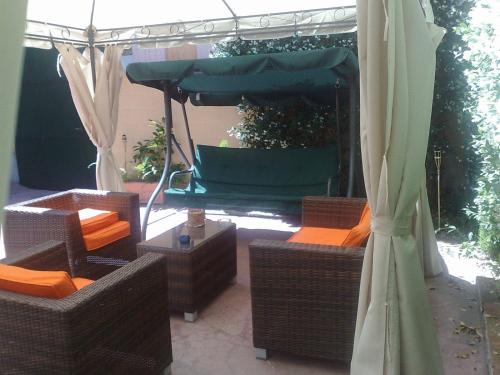 a patio with wicker chairs and an umbrella at Hotel Bogart Milano in Milan