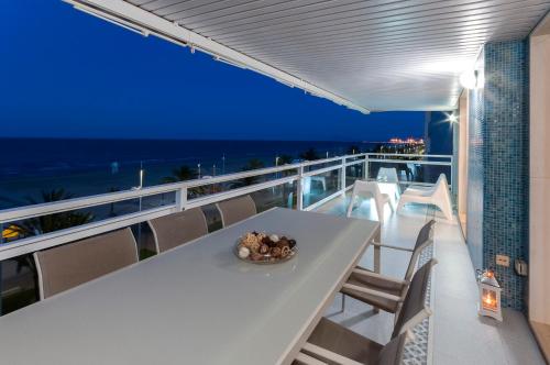 a table on a balcony with a view of the ocean at AG Turquesa Premium in Gandía