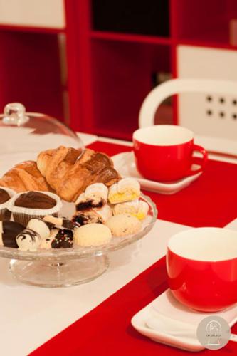 Una mesa con un plato de pasteles y una taza de café. en Da Zia Lalla, en Matera