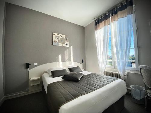 Un dormitorio con una cama grande y una ventana en L'Escale de la Gare en Saumur