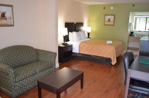 a hotel room with a bed and a couch at Quality Inn & Suites Orlando Airport in Orlando
