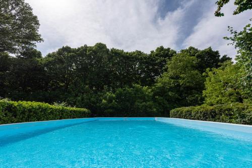 a blue swimming pool with trees in the background at Country house pisani 120SQM in Pernumia