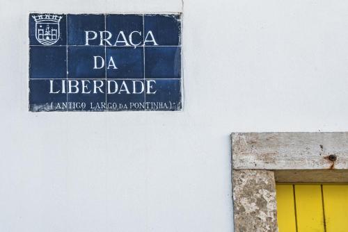 a sign on the side of a building with a yellow door at Lemon Tree Stay in Faro